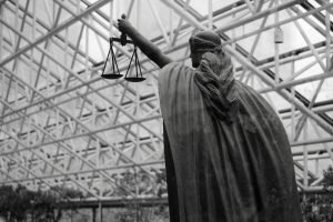 Statue of lady justice holding scales indoors